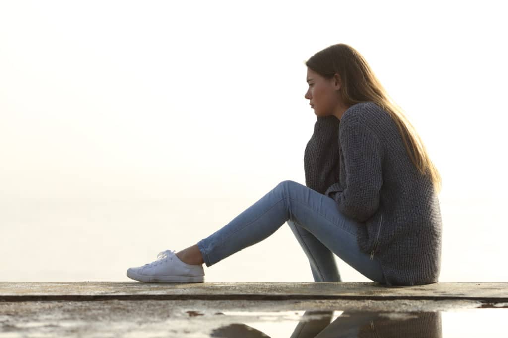 Sad girl looking away alone outdoors